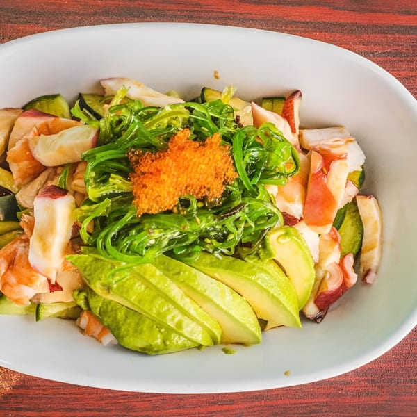 Akita Sushi Gourmet's vibrant seafood salad with avocado, seaweed, and roe in a white bowl.