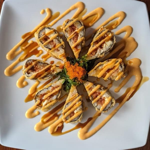 Eight pieces of Akita Sushi's fried sushi rolls, drizzled with sauce and garnished with roe.