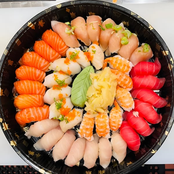 A large platter of Akita Sushi Gourmet's nigiri sushi, including salmon, tuna, shrimp, and white fish.