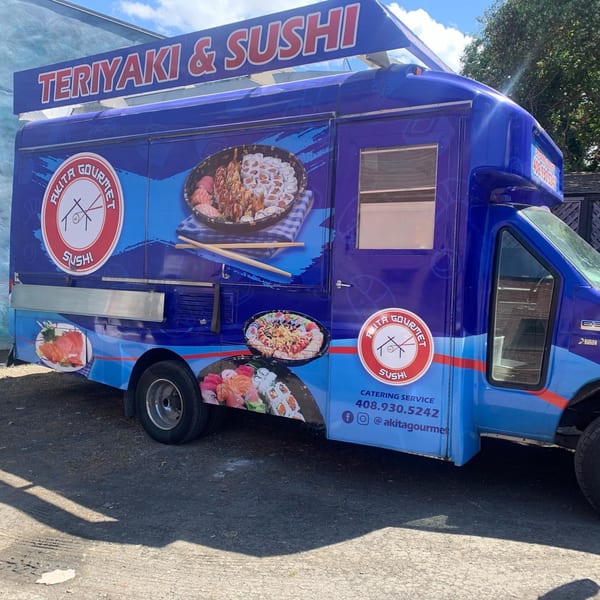 Akita Sushi Gourmet food truck, blue with "Teriyaki & Sushi" sign and sushi platters.