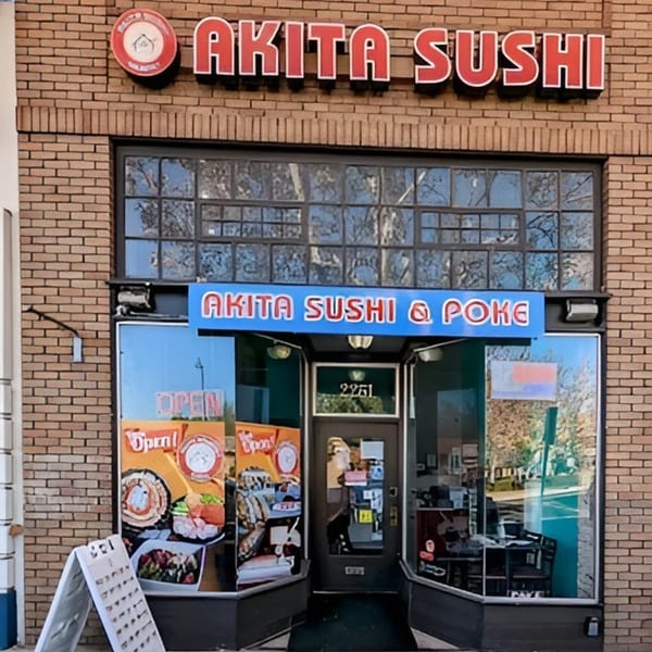 Exterior of Akita Sushi restaurant with a brick facade, large windows, and prominent signage.