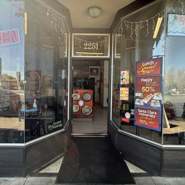 The exterior of Akita Sushi Gourmet Inc, showing the entrance with specials and an "Open" sign.